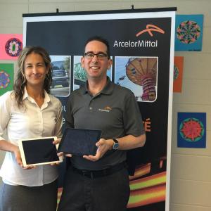 Marie-Hélène Lavoie, enseignante de 6e année à l’école des Coeurs-Vaillants de Contrecoeur et Louis-Philippe Péloquin, directeur des communications d’ArcelorMittal Produits longs Canada, avec deux des iPad remis à la classe grâce au don d’ArcelorMittal.